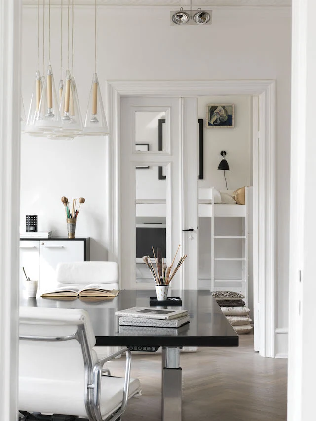 In the office, a black dining table from Gubi serves as a desk, over which Flos Fucsia lights hang.