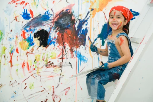 Portrait of girl (4-5) painting wall