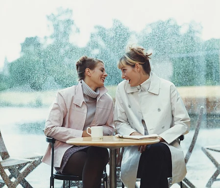 Two Women Talk at Cafe Table