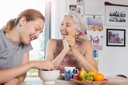 Mother and daughter laughing at breakfast table