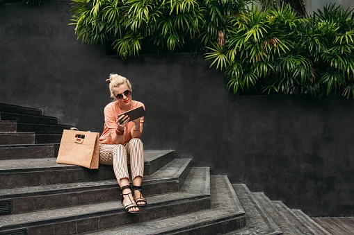 Caucasian woman using digital tablet on stairs