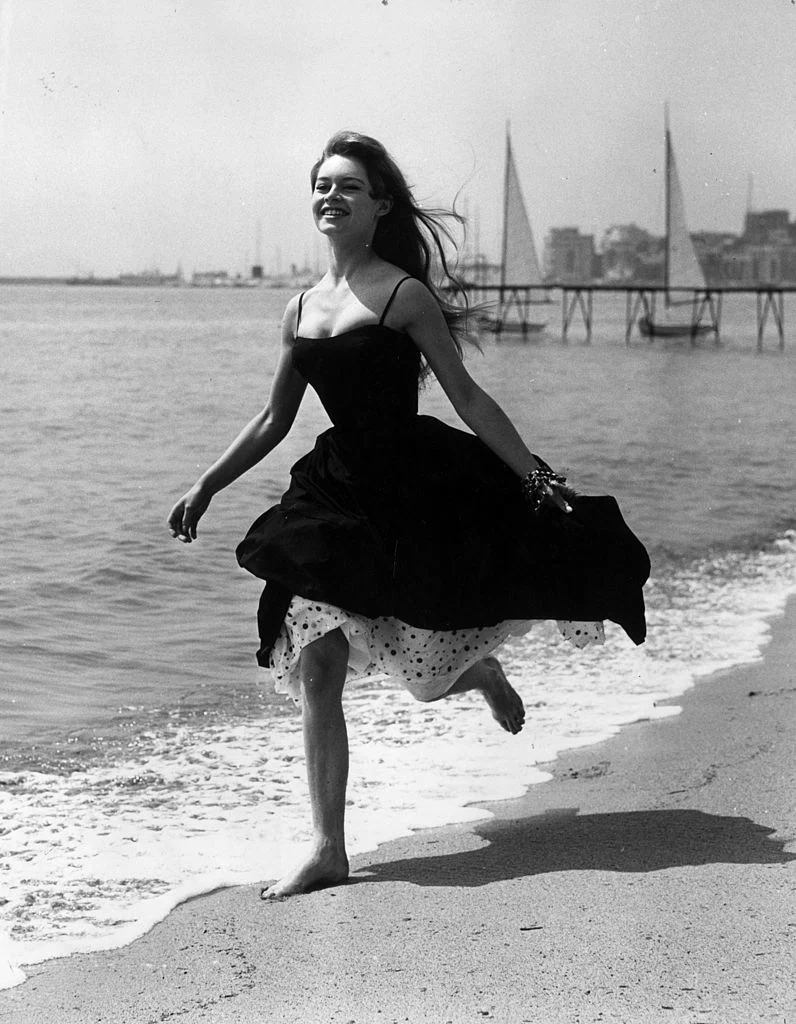 Running barefoot on the sands at Cannes, French film star, Brigitte Bardot (Camille Javal). (Photo by George W Hales/Getty Images)
