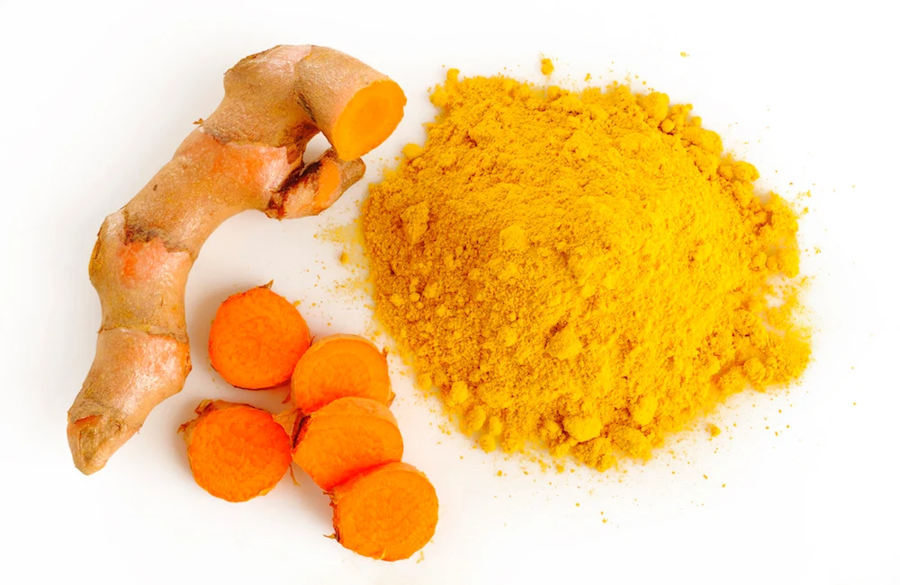 Turmeric root and powder on white background