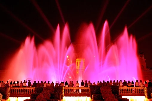 Spain, Catalonia, Barcelona, Spectators watching Fountain of Montjuic located at the head of Avenida Maria Cristina