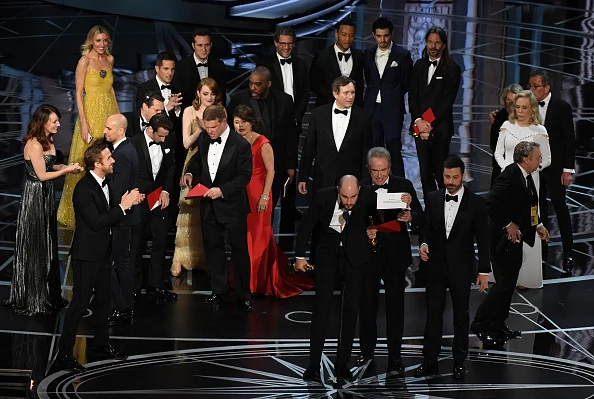 "La La Land" producer Jordan Horowitz (front C) shows the card saying "Moonlight" won the best picture as actor Warren Beatty (front 4R), and Host Jimmy Kimmel (3R) look on at the 89th Oscars.