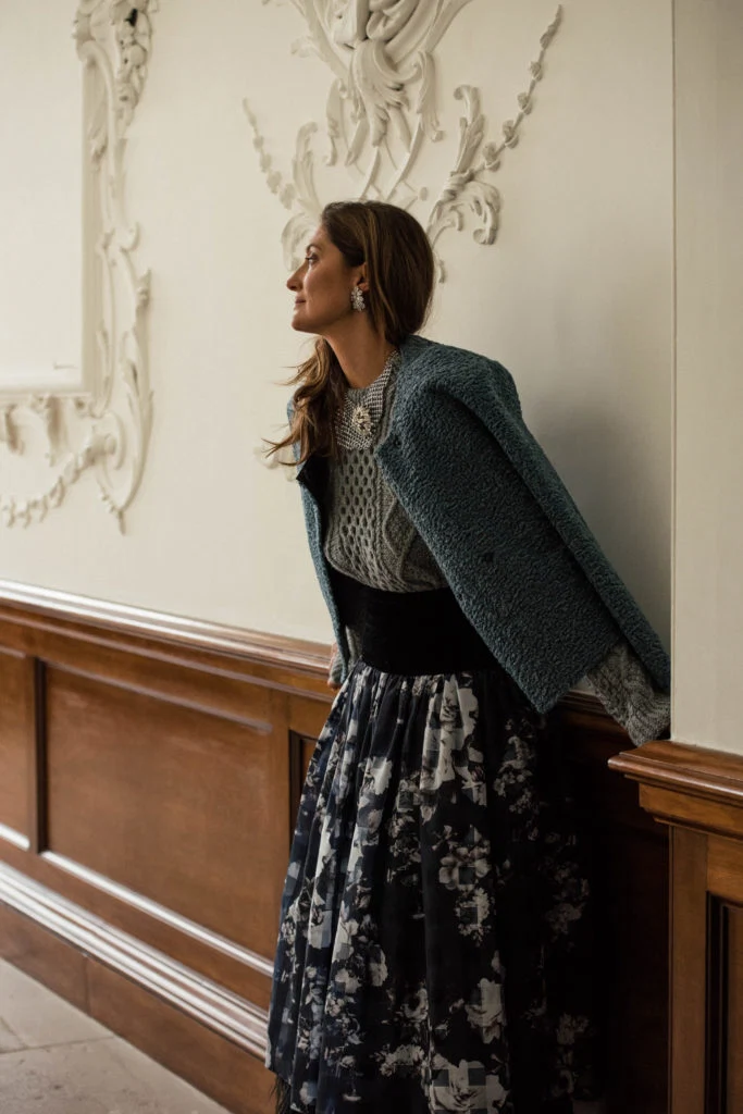 Grey cable knit sweater, €330 at fayedinsmore.com and The Marvel Room, Brown Thomas, printed skirt with feather trim by Sarah Murphy, €480 at havanaboutique.ie, reversible jacket by Stand, €350 at costumedublin.ie, vintage mesh necklace, €679, camelia studs, €219; both at loulerie.ie