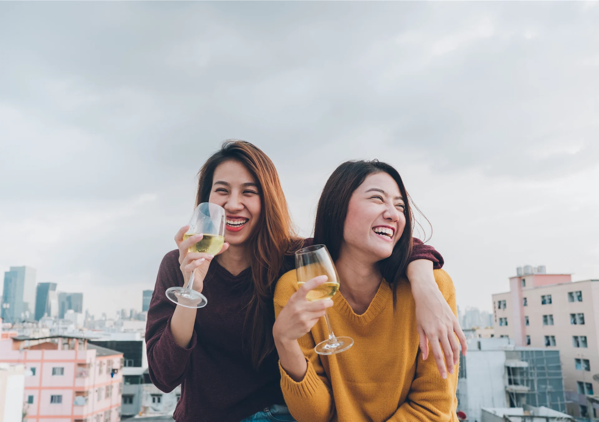 Happy asia girl friends enjoy laughing and cheerful sparkling wine glass at rooftop party,Holiday celebration festive,teeage lifestyle,freedom and fun.lesbian couple.