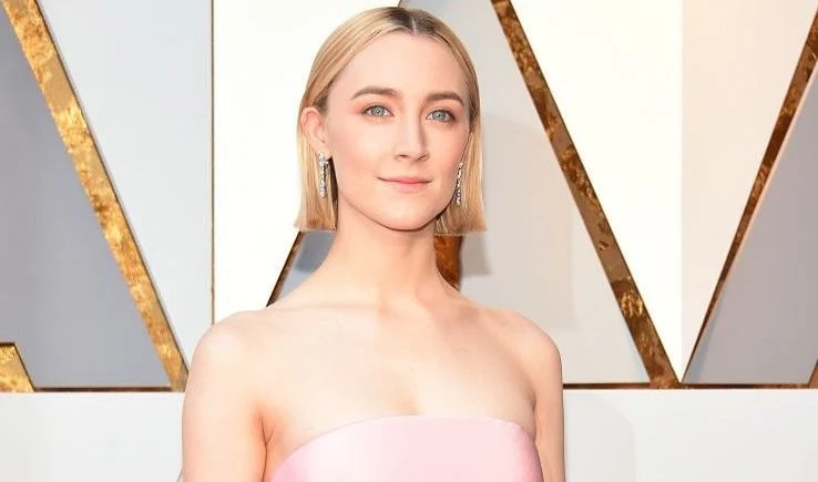 woman with short blonde hair wearing a light pink dress