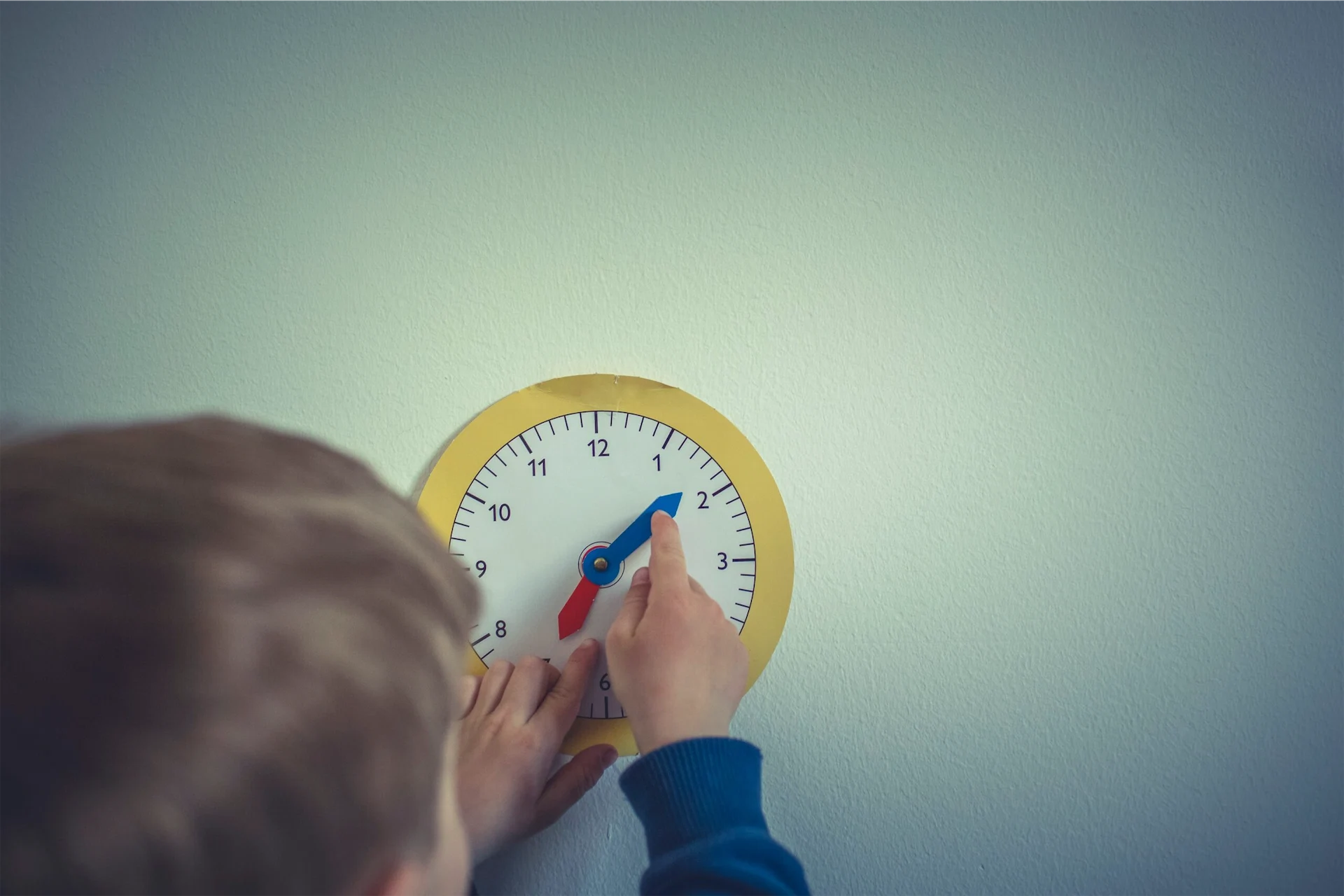 Child changing the hands on a clock