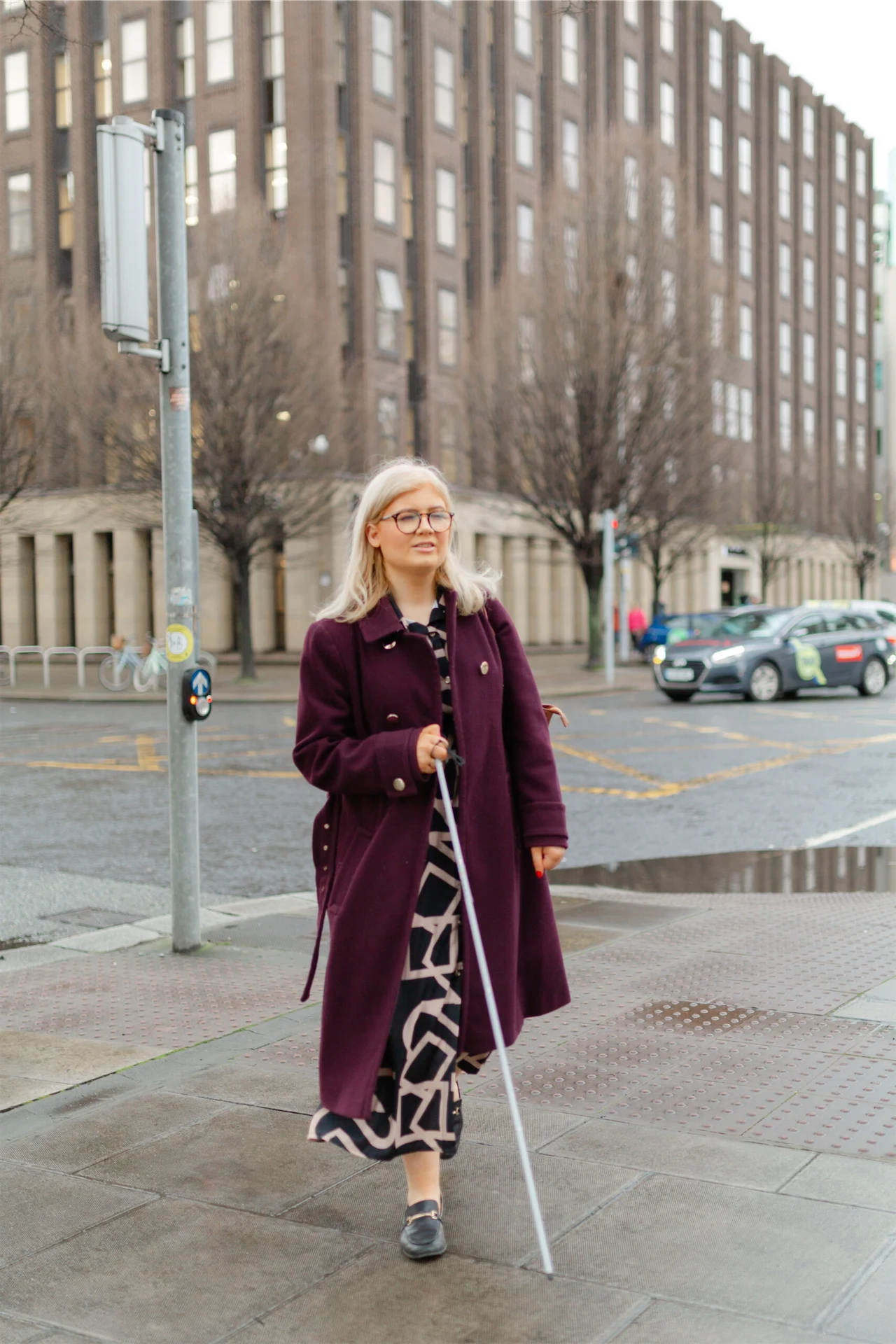 Niamh Donnelly uses her symbol cane as she walks down the road.