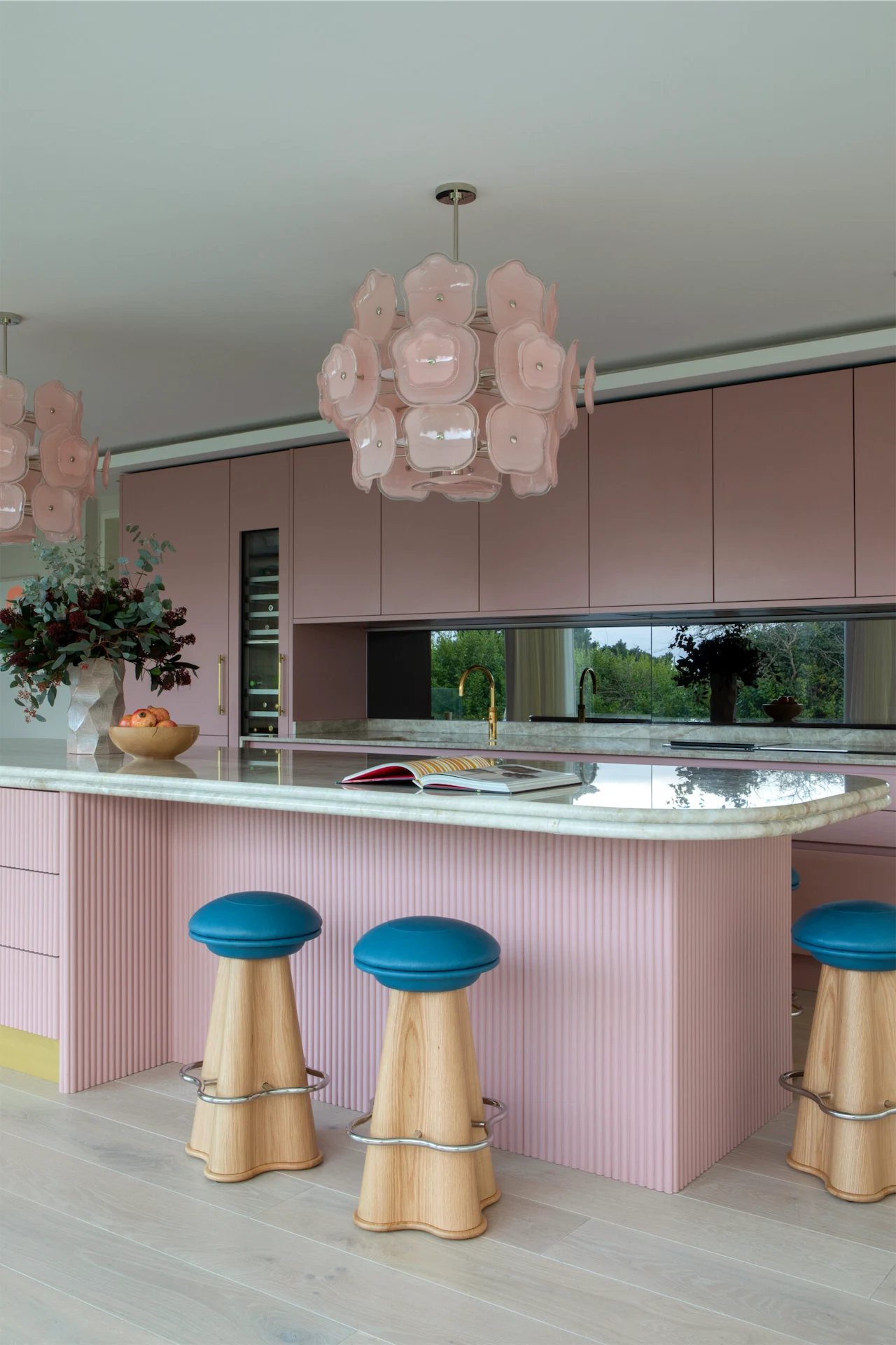The bar stools are by Irish designer Bryan O’Sullivan, while  the mirrored backsplash adds a spacious feel and cleverly reflects the garden outside.