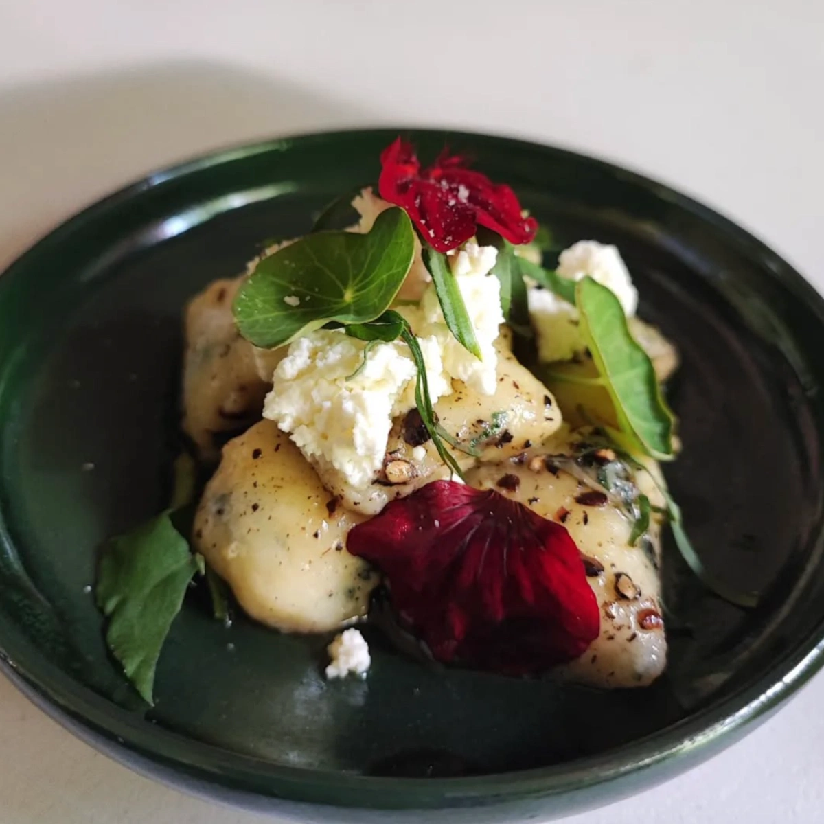 La Cocina Cuevas' potato dumplings with Alexanders seed butter sauce and nasturtium.