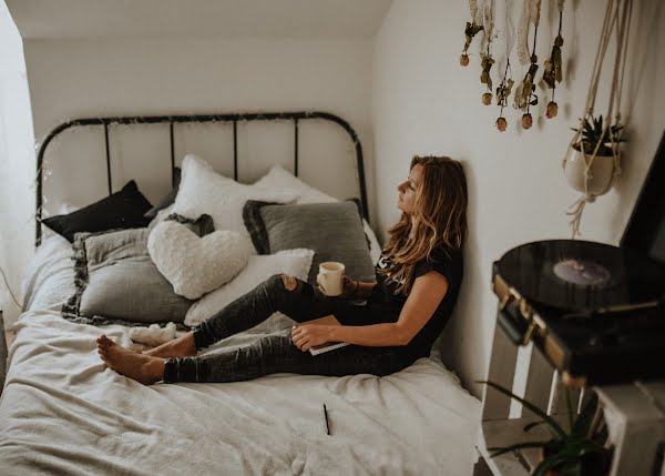 woman sitting on bed relaxing with a cup of tea